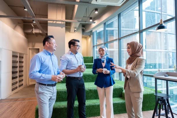 Asian business professionals discussing company planning in a modern office.