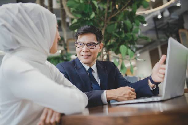 Malaysian business owner discussing asset protection strategies with a financial adviser